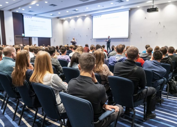 Image of a conference that takes place in a large conference room, workshop for young professionals, training in a large conference room, adult training